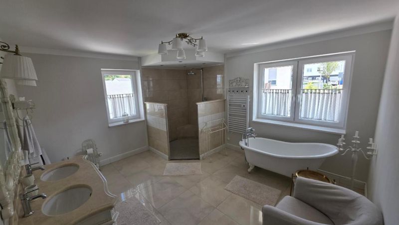 Badezimmer mit freistehender Badewanne und Dusche